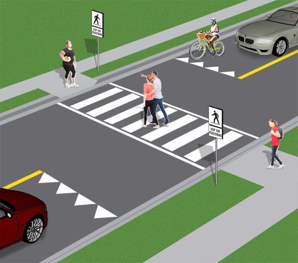 diagram of a pedestrian crossover. The image shows a mid-block pedestrian crossover on a two-lane roadway. A ladder crosswalk, consisting of many white parallel bars between two white outer lines, runs across the roadway. A yield to pedestrians line made of white triangles with the bottom points facing the direction of approaching traffic appears on the roadway in each direction of travel before the crossover. These lines look like shark teeth. A rectangular sign with a black symbol of a person crossing from right to left on a white background is installed at the crossover on the side of the roadway. There is also a sign which reads “stop for pedestrians” under that sign. The signs are also installed on the other side of the crossover, but the black symbols show a person crossing from right to left. Pedestrians are crossing the road. Cars and a bicycle are stopped at the shark teeth lines. They must wait until pedestrians are on the sidewalk across the road before they proceed.