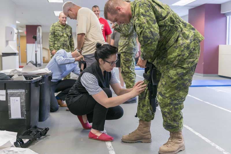 Major Toppa (right) receives a knee brace from Rebecca (left) one of the representatives from knee brace manufacturer Spring Loaded Technology which travelled to the Army Headquarters at 110 O’Connor in Ottawa, Ontario, to demonstrate and test their knee braces on July 12, 2016. Photo by: Cpl Andrew Wesley, Directorate of Army Public Affairs LF03-2016-0114-002